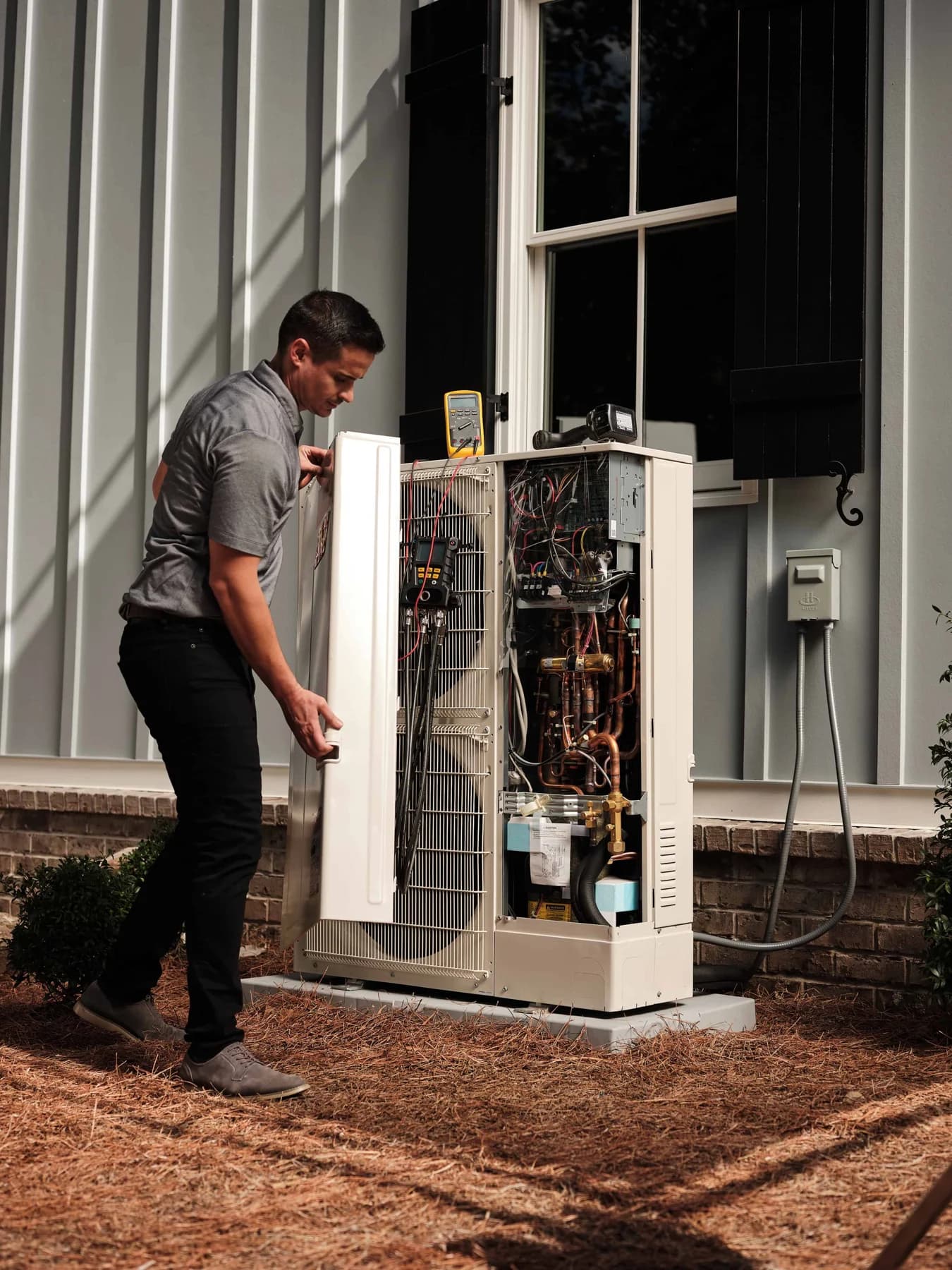 UniColorado technician taking an electrical reading at an outdoor unit